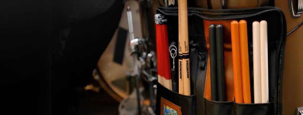 ProMark stick bag hanging on a drum kit with sticks and Hot Rods